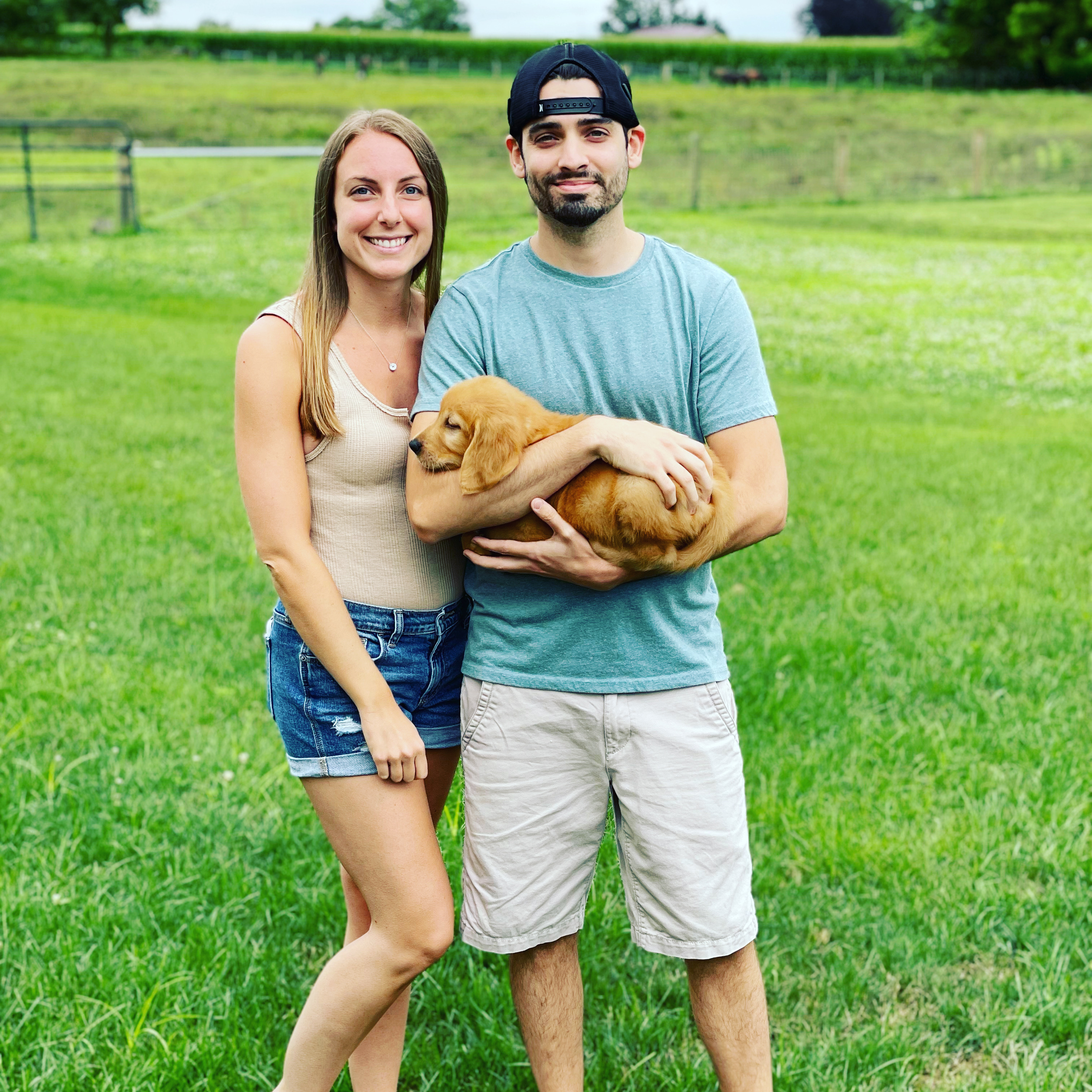 happy couple with golden retriever puppy